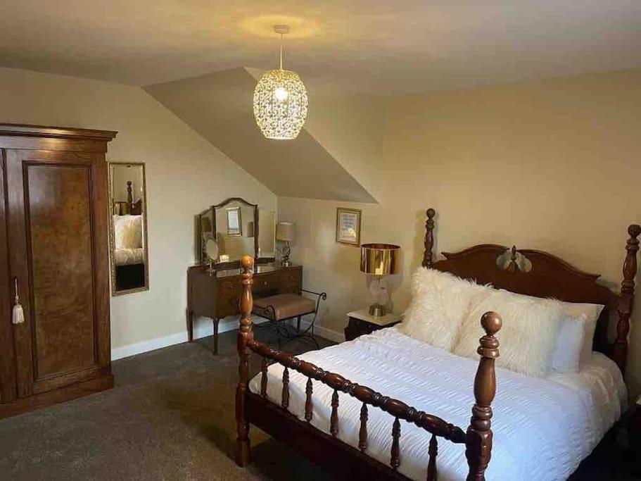a bedroom with a bed and a dresser and a mirror at The Barn, Romantic country getaway in Dyserth