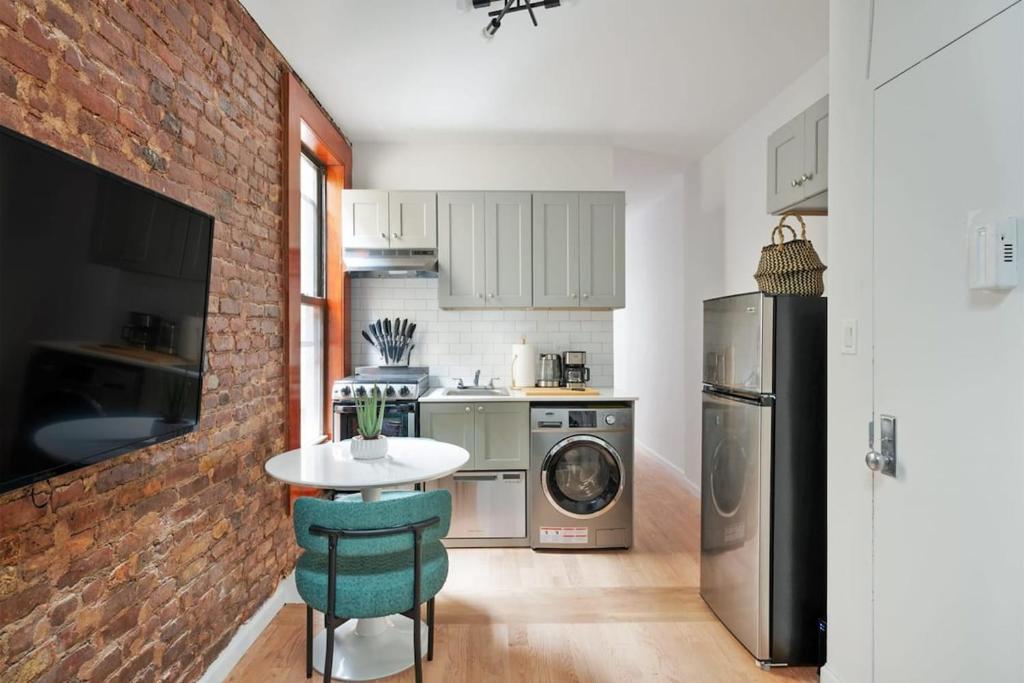 uma cozinha com uma mesa e uma parede de tijolos em 153-5A Charming 2BR LES W D em Nova Iorque