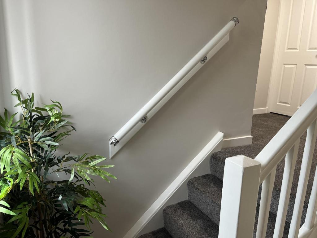 a staircase with white railings in a house at Hesed Home in Edinburgh