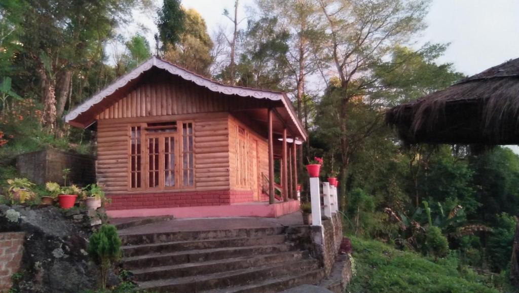 een klein houten huis op een trap bij Kalimpong Paruhang farmhouse in Pedong