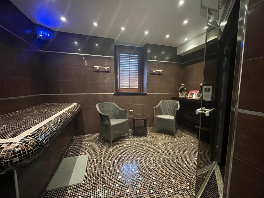 a bathroom with a bed and two chairs and a shower at Domaine du Clos Fleuri - Spa in Honfleur