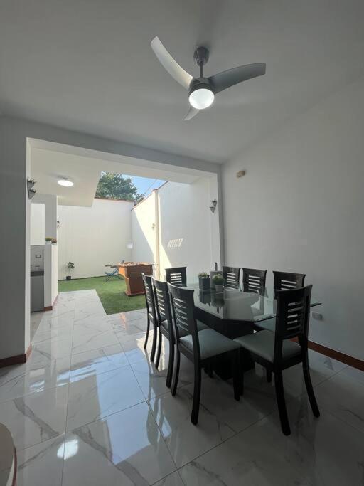 a dining room with a black table and chairs at Casa moderna en Tarapoto in Tarapoto