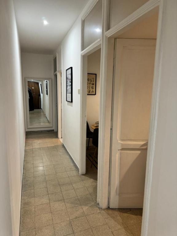 korytarz z białymi drzwiami i podłogą wyłożoną kafelkami w obiekcie Nuova Apertura Colosseo , Pietra Apartment w Rzymie