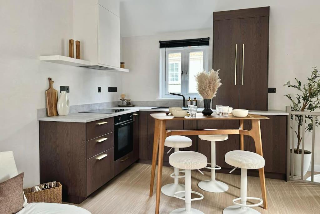 a kitchen with a table and some stools in it at No.1 Lighthouse Dawlish Beach in Dawlish