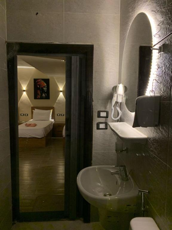 un bagno con lavandino, specchio e letto di Heaven Hostel a Il Cairo