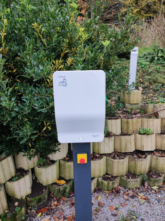 a white box on a pole in front of a garden at Domaine du Clos Fleuri - Spa in Honfleur