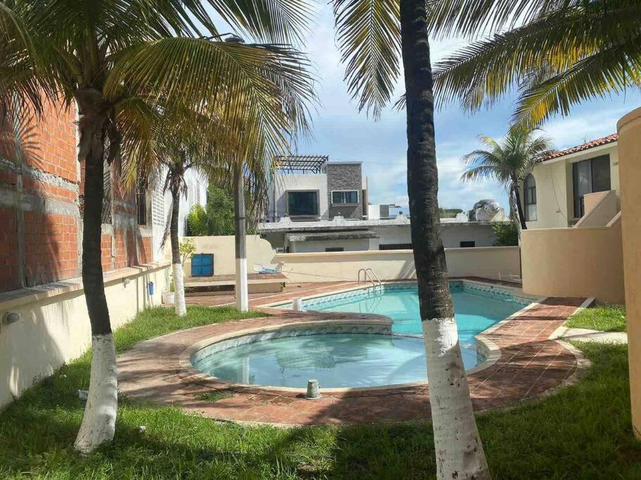 a swimming pool in a yard with palm trees at A 3 cuadras de la playa DPTO c/ Alberca in Boca del Río