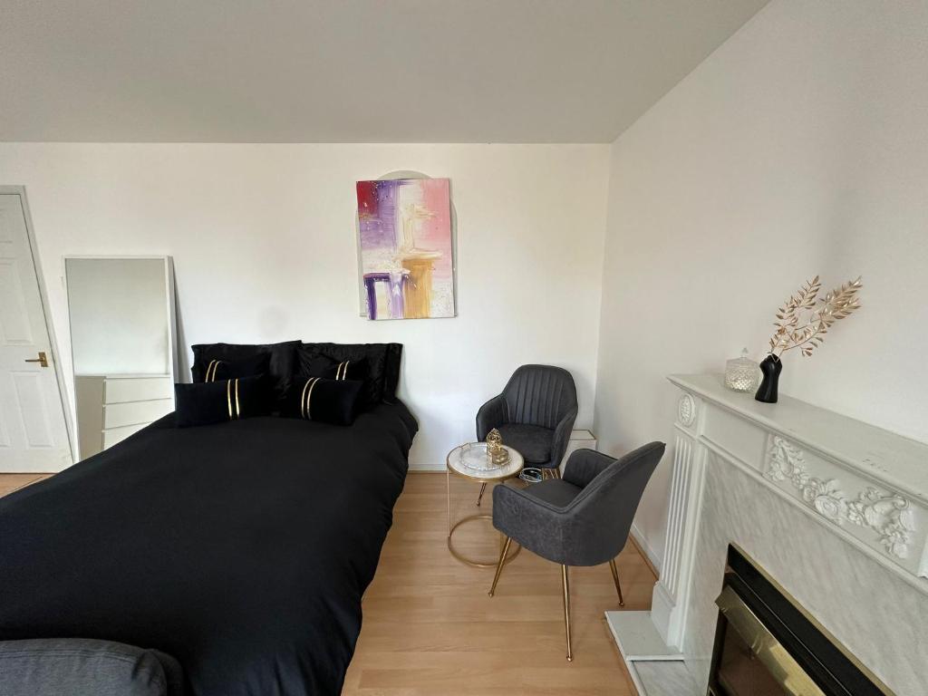 a bedroom with a bed and two chairs and a fireplace at Luxury Stay near London Eye zone 1 in London