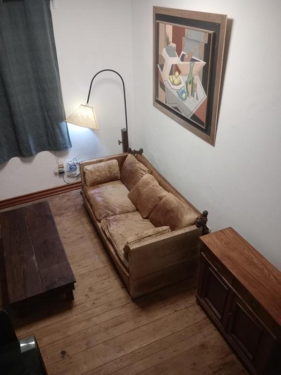 a brown couch in a living room with a table at Casa Bruniel in Montevideo