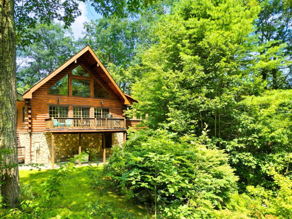 una cabaña de madera en el bosque con árboles en Lake, Kayaks & Sauna - Family & Wellness en Otis