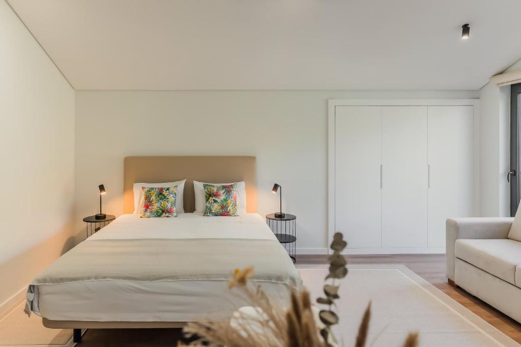 Un dormitorio con una cama grande y un sofá. en Primeiro Quartel Apartments - 4, en Peso da Régua