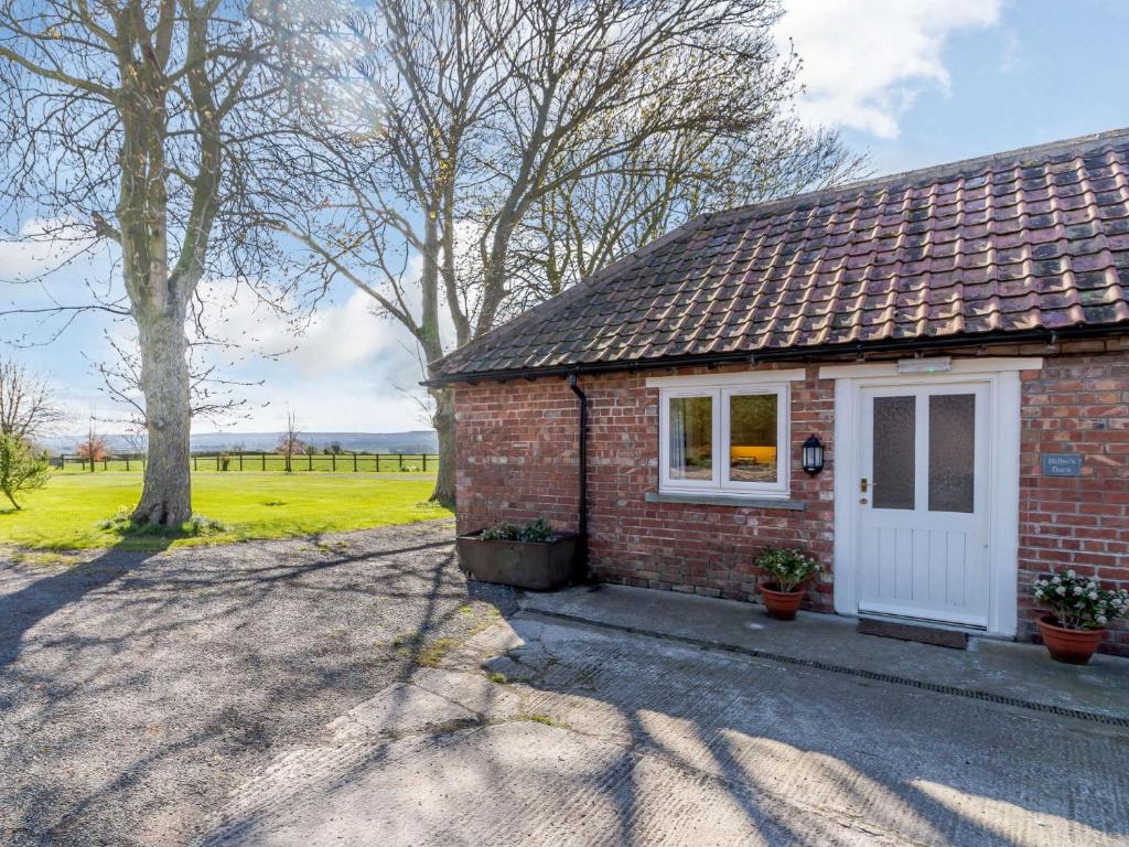 a brick house with a white door and a field at 2 Bed in Thornton le Dale 27112 in Allerston