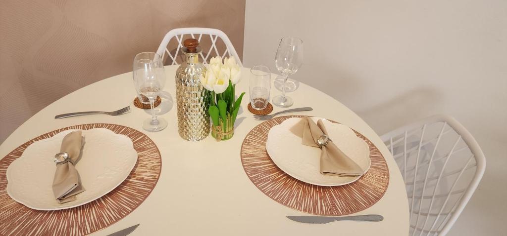 a white table with plates and napkins on it at 50 m do mar, 3 dorm, sacada com vista mar, pitangueiras, vaga de garagem, Pet friendly, berço in Guarujá