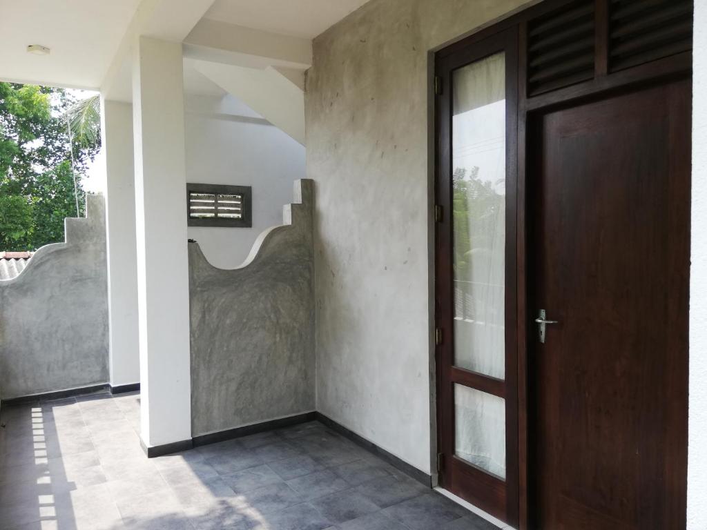 ヒッカドゥワにあるVILLA MAANE by GOODWILLの木製のドアと階段が空いている廊下