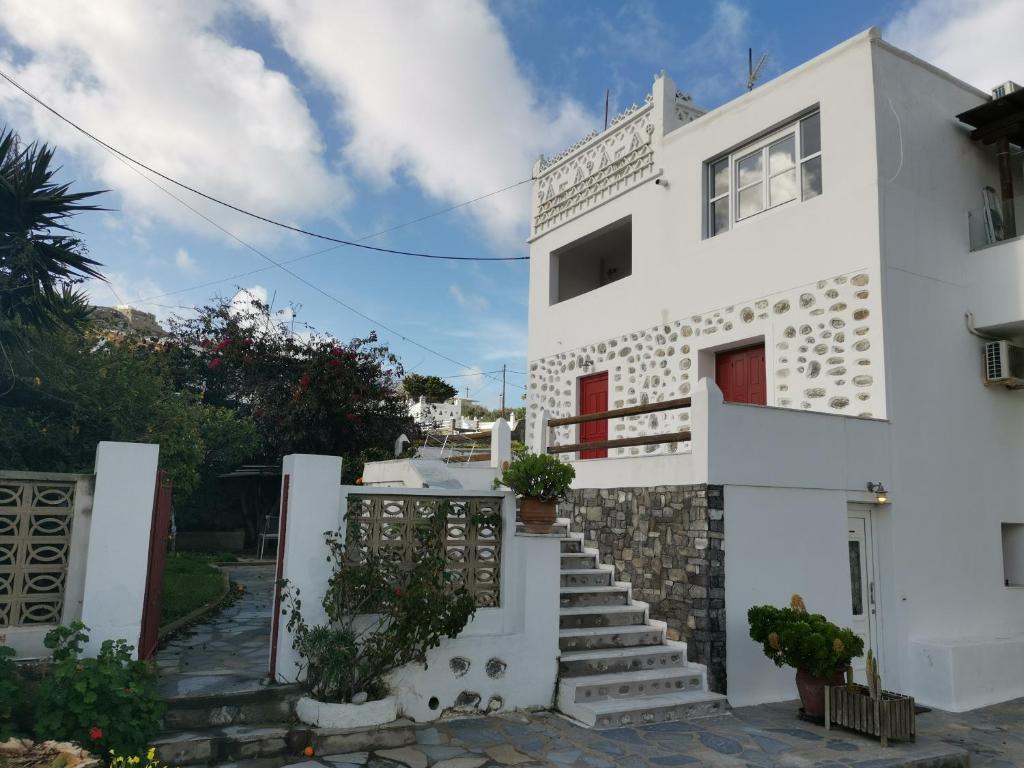 Casa blanca con puerta roja y escaleras en VILLA VASILIS ORNOS en Mykonos ciudad