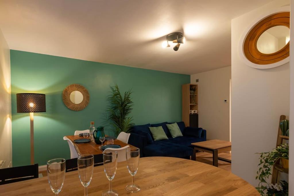 - un salon avec une table et des verres à vin dans l'établissement Balnéo & Sauna, séjour détente aux Teinturiers - Métro Charpennes - Garage, à Villeurbanne