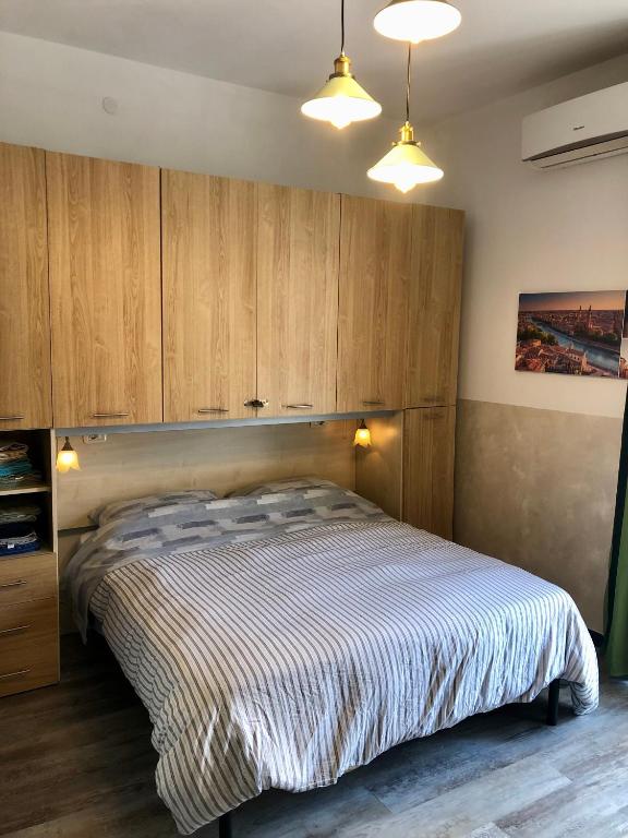 a bedroom with a large bed with wooden cabinets at Appartamento Verona in Verona