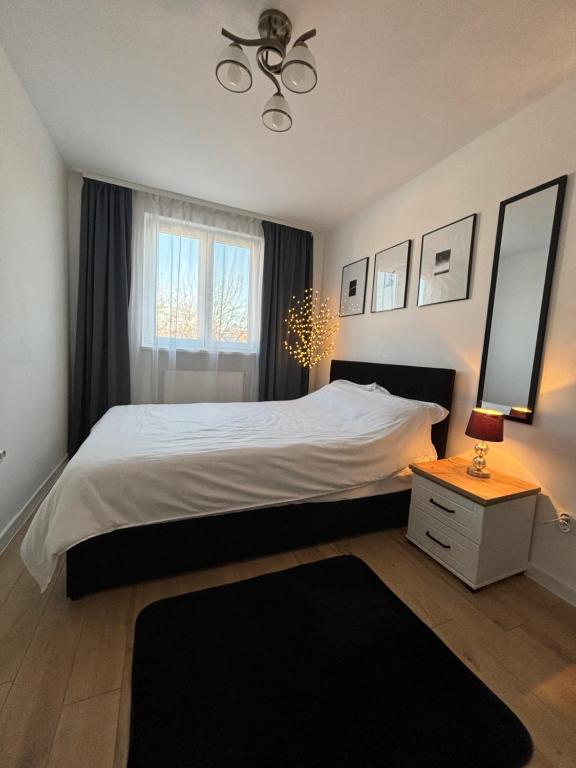 1 dormitorio con 1 cama blanca grande y espejo en Best choice flat, en Târgu Mureș