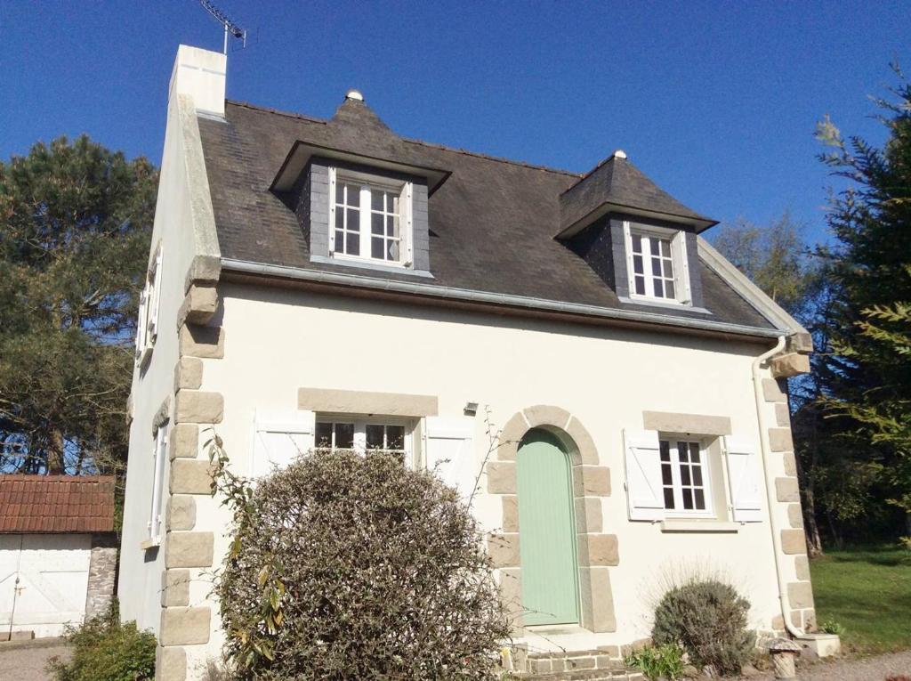 une maison blanche avec un toit noir et une porte verte dans l'établissement 752 - Maison avec jardin à 2km du centre d'Erquy des commerces et des plages sauvages, à Erquy