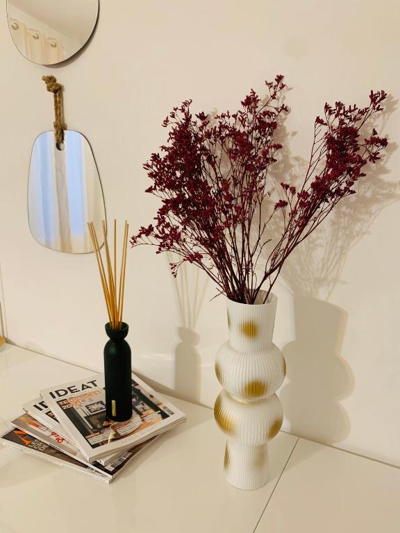une table avec deux vases fleuris et un magazine dans l'établissement Le Bora Cosy House - T2 lumineux et moderne à proximité du métro, à Maisons-Alfort