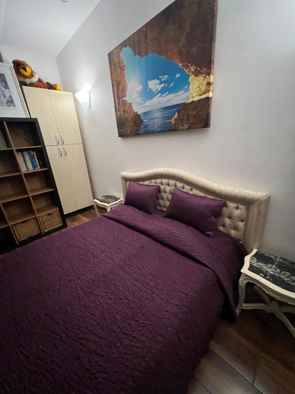 - une chambre avec un lit et une couverture violette dans l'établissement CENTRO Guest House, à Alytus