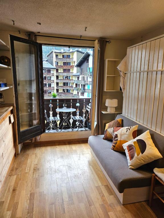 un salon avec un canapé et une grande fenêtre dans l'établissement Cozy Chamonix Ski Studio with Mountain Views, à Chamonix-Mont-Blanc