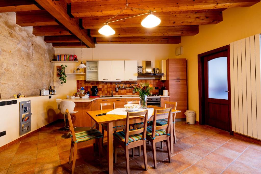 cocina con mesa de madera y sillas en Domus Teja, en Agira