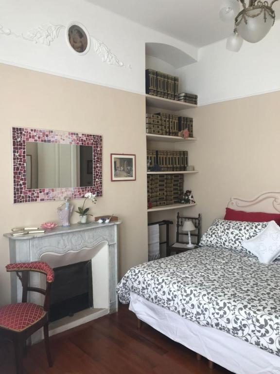 a bedroom with a bed and a fireplace and a mirror at B&B Agapantus in una Villa dell'800 in Dolceacqua