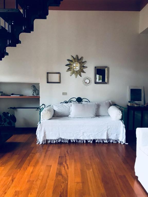 a bedroom with a white bed with a clock on the wall at B&B Agapantus in una Villa dell'800 in Dolceacqua
