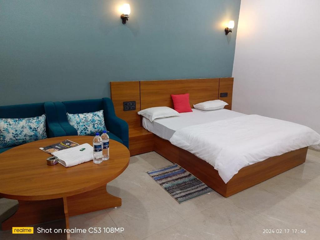 1 dormitorio con cama, mesa y sofá en Singanama RESORT, en Pachmarhī