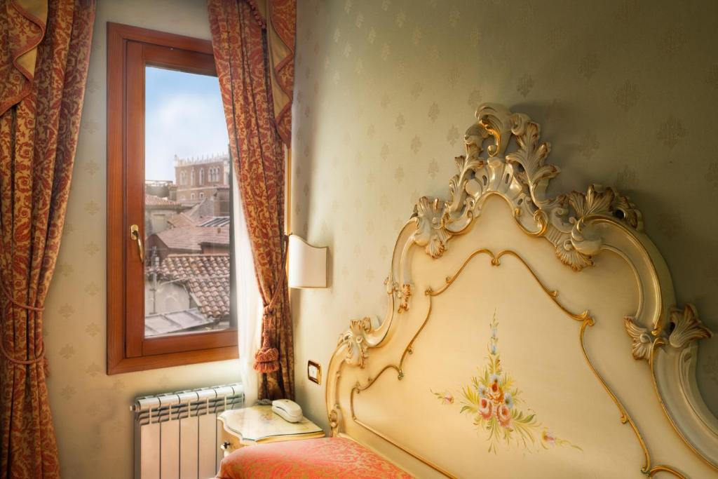 a bedroom with a bed and a window at Locanda Al Leon in Venice