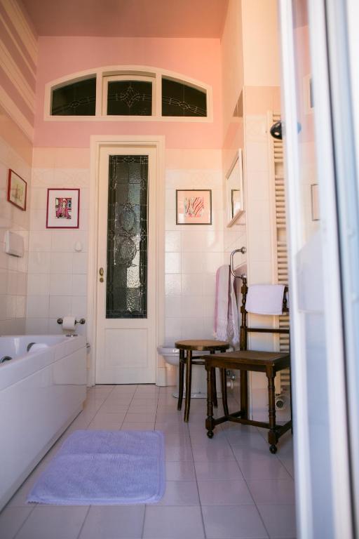 a bathroom with a tub and a sink and a table at B&B Agapantus in una Villa dell'800 in Dolceacqua