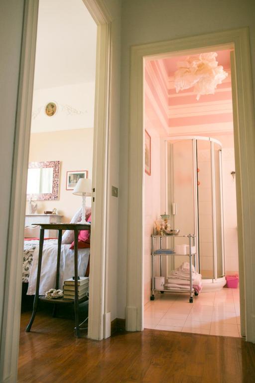 a room with a bed and a table and a mirror at B&B Agapantus in una Villa dell'800 in Dolceacqua