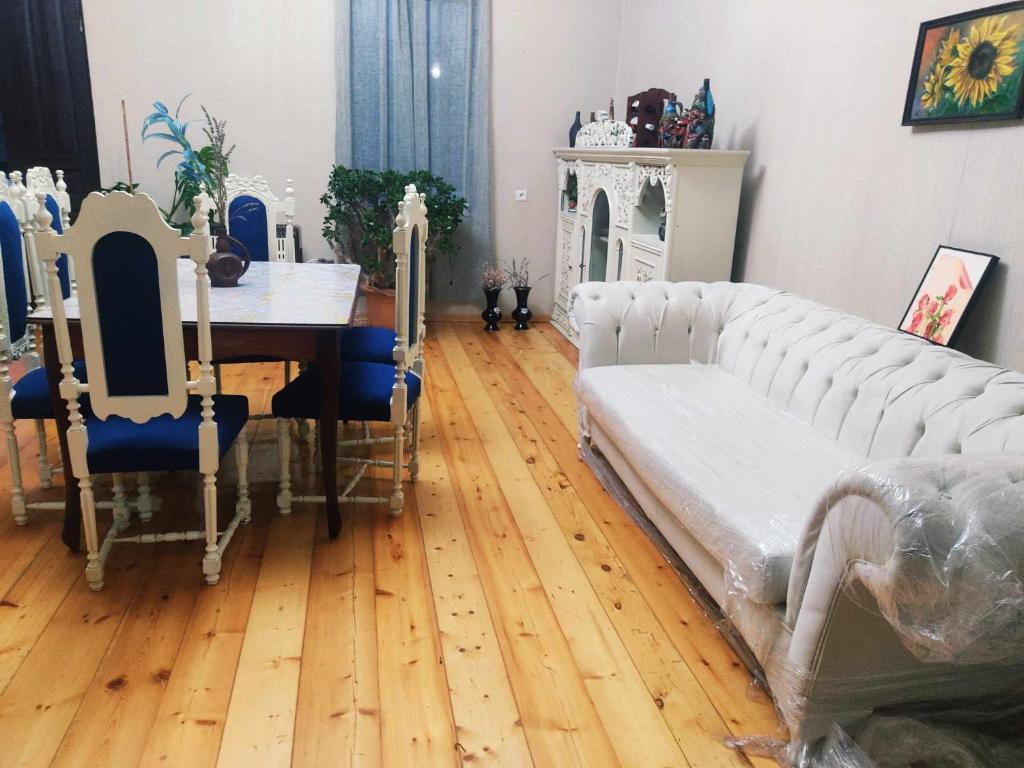 een woonkamer met een tafel en een witte bank bij Grandmother Naziko in Vani