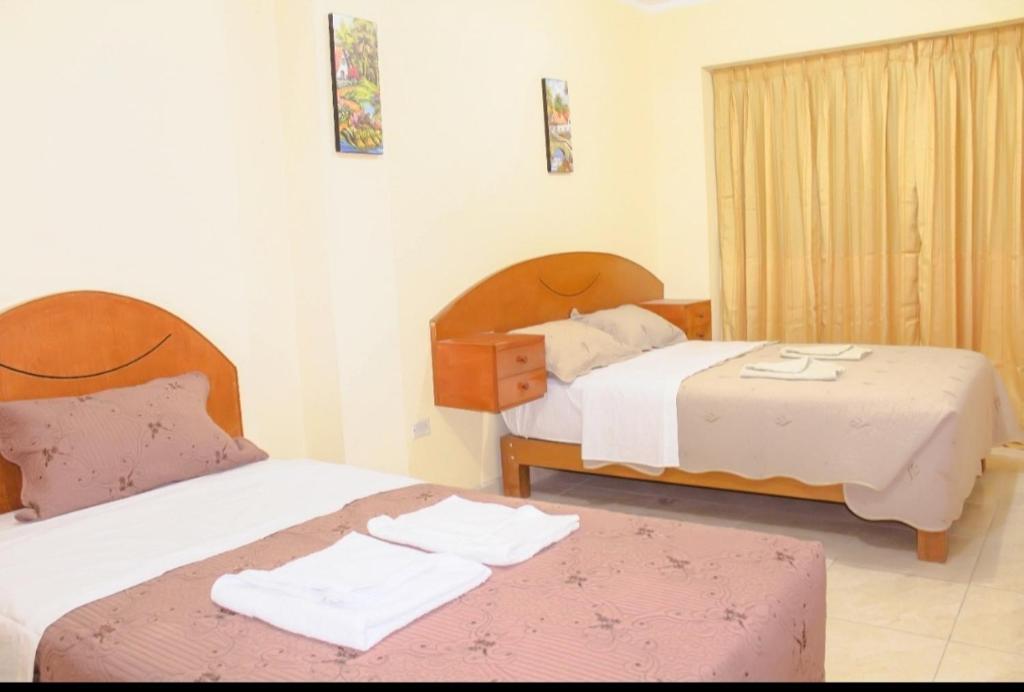 1 dormitorio con 2 camas y toallas. en Dominius Hotel, en Olmos