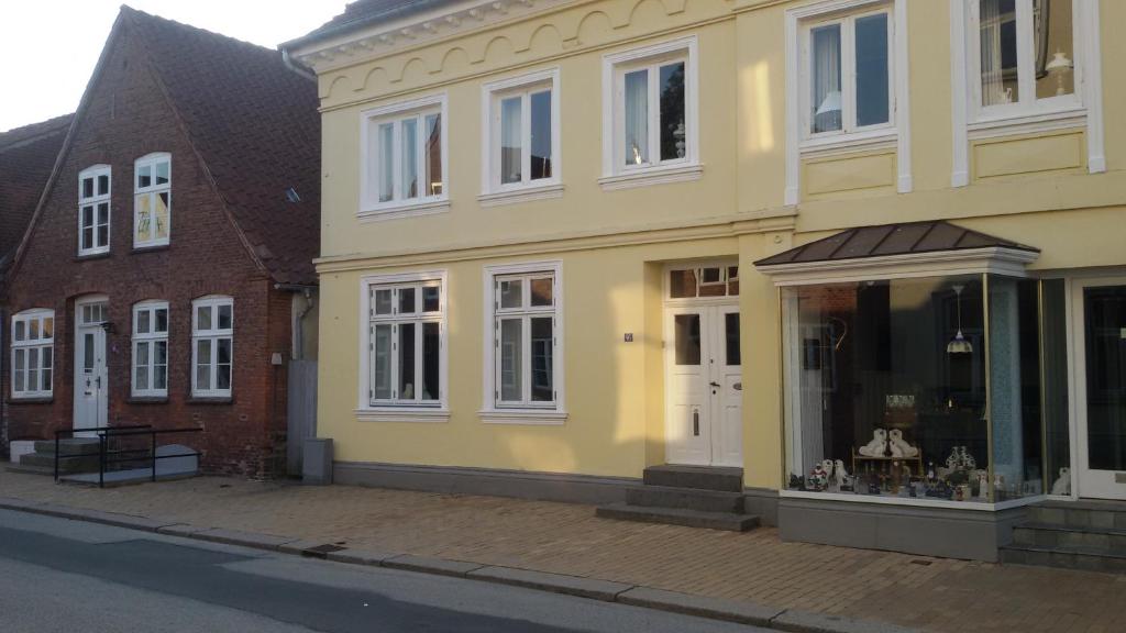 ein gelbes Gebäude mit einem Ladefenster auf einer Straße in der Unterkunft Østergade 46 in Tønder