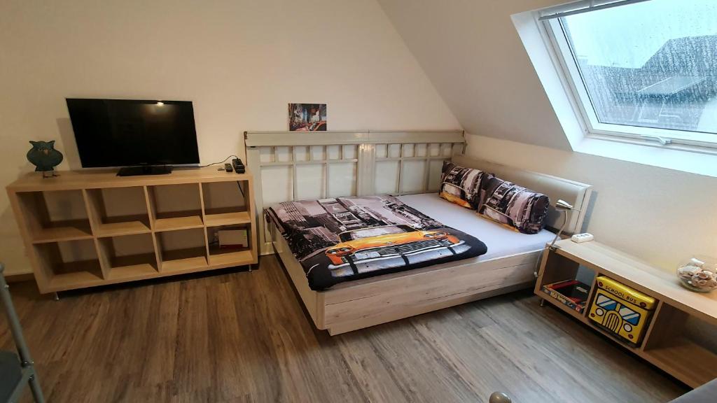 Dormitorio pequeño con cama y TV en FRANKES SLEEP INN, 2 Wohnungen 2 Betten und 5 Betten, Sauna, en Velbert