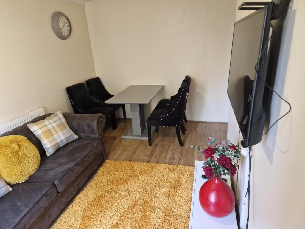 a living room with a couch and a table at Dagenham Contractors Favourite in Dagenham
