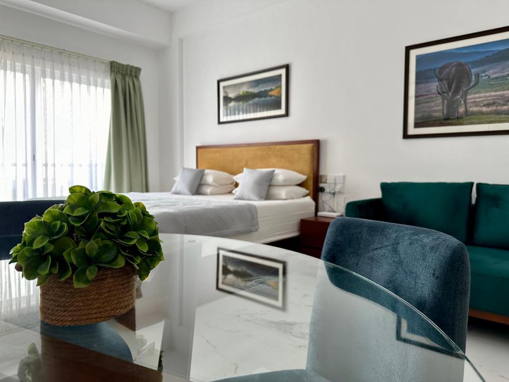 ネゴンボにあるOcean Breeze Hotel Residencies BritLanka Apartments Negomboのリビングルーム(ベッド1台、テーブル、ソファ付)