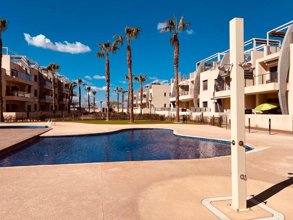 una piscina frente a algunos edificios de apartamentos en Elisa Bay apartment Mil Palmeras, en Torre de la Horadada