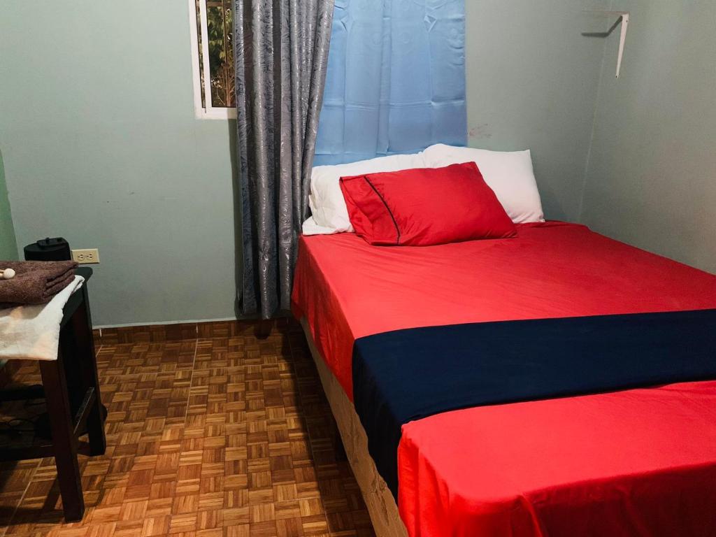 1 dormitorio con 2 camas de color rojo y azul en Casa en Las termales, en Gracias