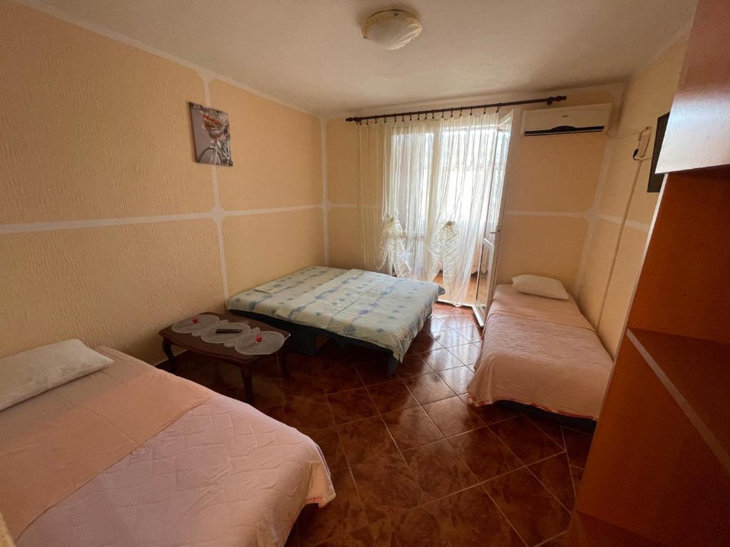 mały pokój z 2 łóżkami i oknem w obiekcie Apartman Marković w mieście Meljine