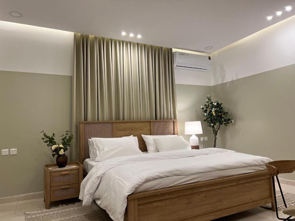 una camera da letto con un grande letto con lenzuola bianche di بوتيك هاوس بتصاميم مميزة وأنيقة a Hail