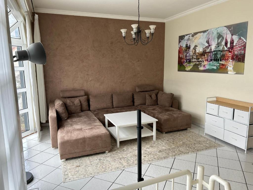 ein Wohnzimmer mit einem Sofa und einem Tisch in der Unterkunft Ferienhaus mit Privatparkplatz, Terrasse und Kamin in Bremen