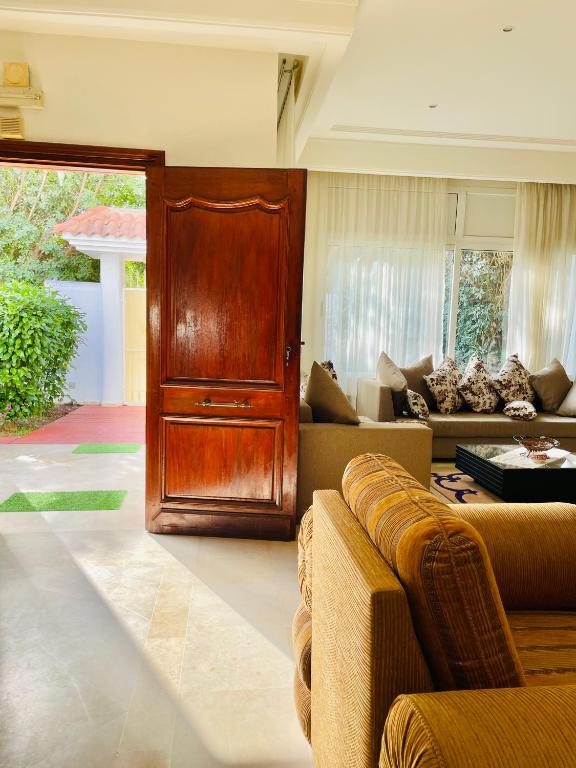 sala de estar con puerta de madera y sofá en Superbe villa meublée Ennacer 95€/j, en Burj at Turkī