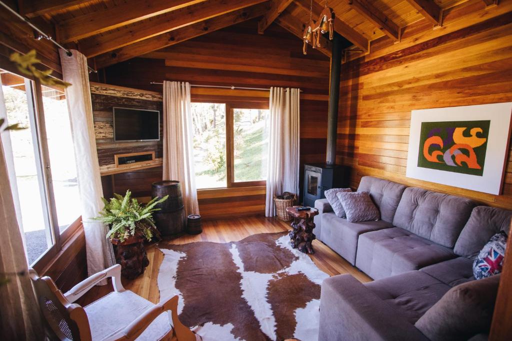 a living room with a couch and a tv at Green Valley Refuge in Urubici