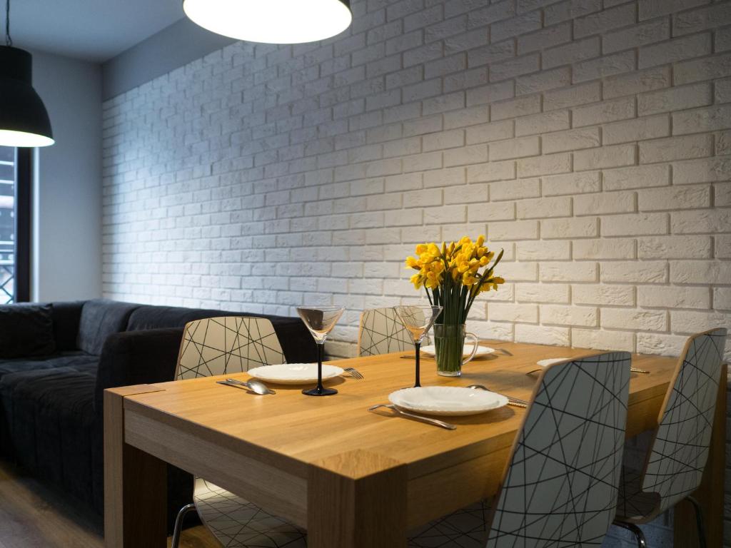 a wooden table with chairs and a dining room at Apartament Great koło opery i miejscem postojowym w garażu in Białystok