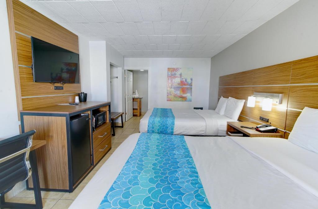 a hotel room with two beds and a flat screen tv at Oceans 2700 in Virginia Beach