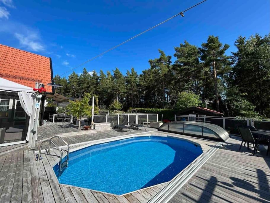 een zwembad op een terras naast een huis bij Guest house or Loft with summer Pool in Bro