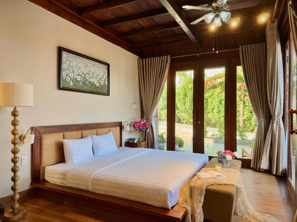 a bedroom with a bed in a room with windows at Hapu Garden homestay in Buôn Enao